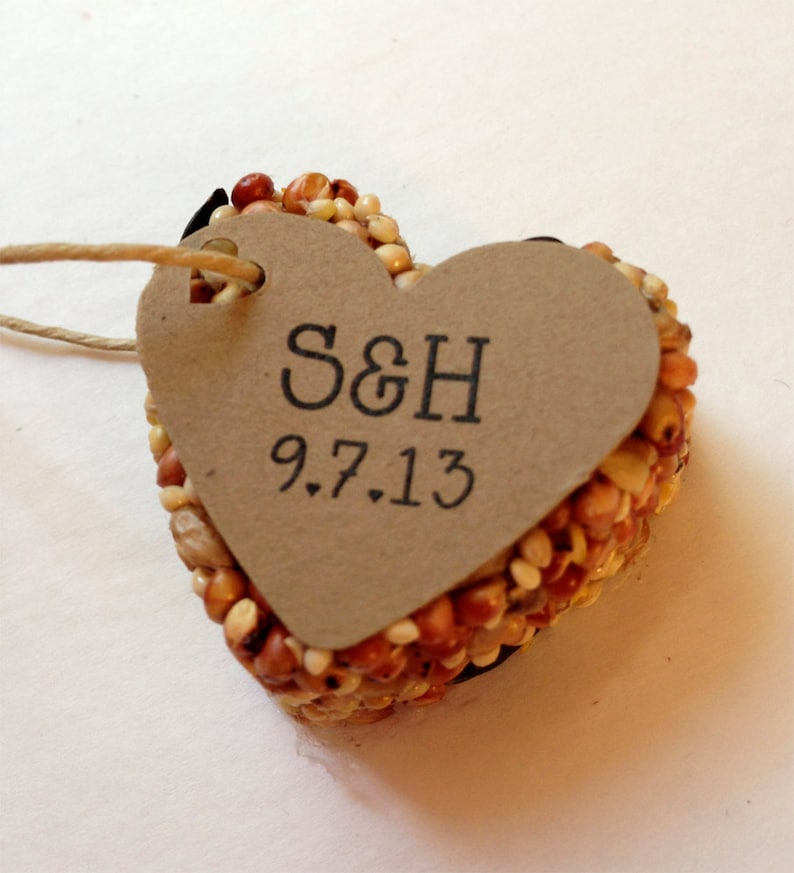 May include: A heart-shaped bird feeder made of seeds with a brown paper tag attached. The tag has the initials "S&H" and the date "9.7.13" written on it.