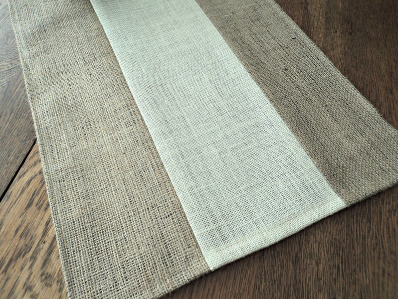Pode incluir: Um corredor de mesa de juta listrado em marrom e branco. O corredor tem uma faixa central branca e duas faixas marrons de cada lado.