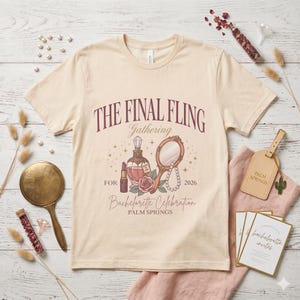 May include: Cream-colored t-shirt with the text "THE FINAL FLING Gathering" and "Bachelorette Celebration PALM SPRINGS 2026". The graphic includes a perfume bottle, lipstick, mirror, and rose. Other items include a hand mirror, invitations, and a luggage tag.