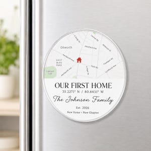May include: A round, clear magnet with a map design. The magnet features a map of a neighborhood with street names, a house icon, and the text "OUR FIRST HOME" and "The Johnson Family". Includes coordinates and the year 2026.