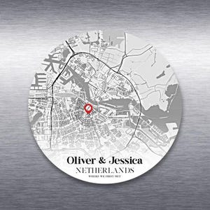 May include: A circular map print of Amsterdam, Netherlands, with a red marker indicating a location. The print includes the names "Oliver & Jessica" and the text "WHERE WE FIRST MET". The map is in grayscale.