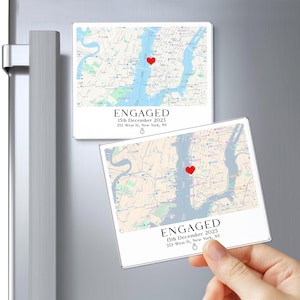 May include: Two rectangular magnets with a map design, a red heart, and the word "ENGAGED". The text includes the date "15th December 2025" and an address in New York. One magnet is on a refrigerator.