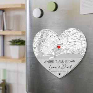 May include: A heart-shaped magnet featuring a map design with a red heart marking a location. The text "WHERE IT ALL BEGAN" is above the names "Luna & David" and coordinates.