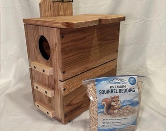 May include: A wooden squirrel house with a circular entrance and three horizontal climbing slats on the side, accompanied by a clear plastic bag labeled Premium Squirrel Bedding featuring an illustration of a squirrel.
