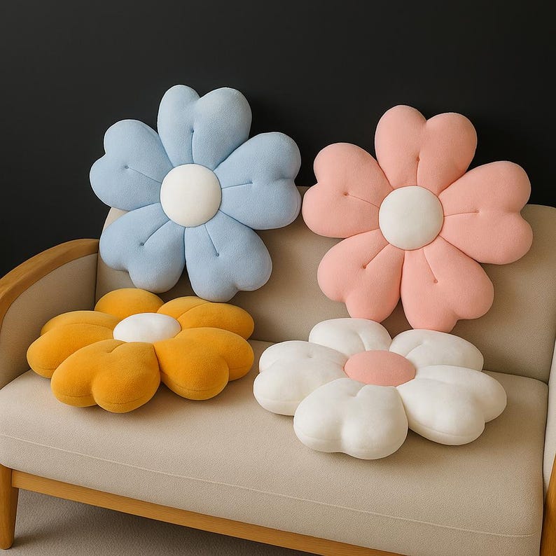 May include: Four flower-shaped throw pillows in pastel colors: light blue, pink, yellow, and white. Each pillow has a white or pink center. The pillows are arranged on a beige sofa, creating a soft and inviting aesthetic.