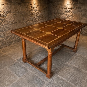 May include: A rectangular wooden dining table featuring a dark brown wood grain surface with a geometric inlay pattern of lighter wood squares and rectangles. The table is supported by four sturdy, cylindrical legs connected by a horizontal base frame.