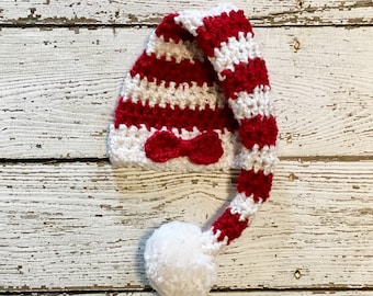 Gorro de bebé a rayas con cola larga y lazo en forma de bastón de caramelo