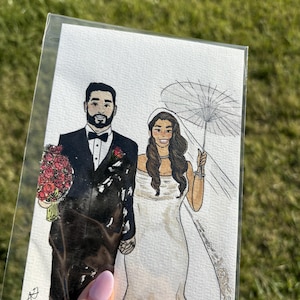 May include: Watercolor illustration of a couple on their wedding day. The groom wears a black tuxedo and holds a bouquet of red roses. The bride is in a white wedding dress and veil, holding a parasol. The artwork is in a clear plastic sleeve.