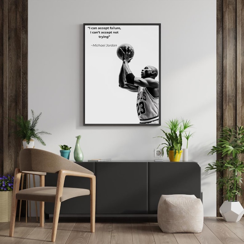 May include: Black and white framed print featuring Michael Jordan shooting a basketball. The print includes the quote "I can accept failure, I can't accept not trying" by Michael Jordan. The basketball player is wearing a jersey with the number 23.