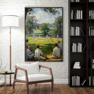 May include: A framed painting showing a cricket match in progress. Players in white attire are on the green field, with spectators in hats and white clothing observing. The artwork has a vintage, impressionistic style, with a focus on light and shadow.