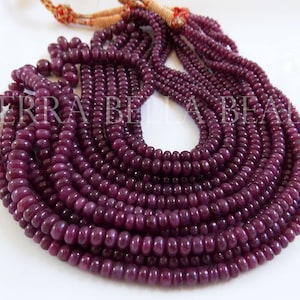Peut inclure: Un brin de perles de rubis violet foncé, d'environ 4 mm de diamètre, avec une finition lisse et polie. Les perles sont enfilées sur un cordon fin et sont prêtes pour la fabrication de bijoux.