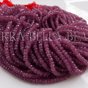 May include: A strand of purple faceted gemstone beads. The beads are small and round, and they are strung on a thin thread. The beads are all the same size and shape, and they are arranged in a random order.