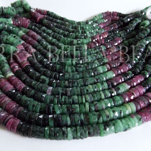 May include: A strand of green and pink gemstone beads. The beads are faceted and have a rough, natural look. The beads are strung on a white thread.