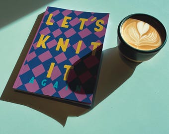 May include: A book titled "LET'S KNIT IT AGAIN" with a geometric pattern in blue, pink, and yellow, next to a cup of coffee with latte art. The book and coffee sit on a light blue surface.