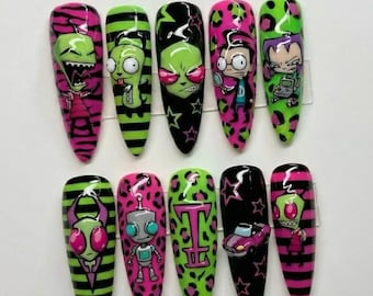 May include: A set of ten long, pointed artificial nails with cartoon character designs. The nails feature vibrant colors like pink, green, and black, with various patterns including stripes, leopard print, and stars. Each nail showcases a different character.