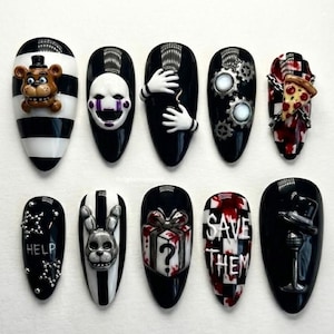 May include: A set of ten black and white nail designs featuring 3D character art. Designs include a bear, a puppet, gears, a pizza, a bunny, a gift, and the text "HELP" and "SAVE THEM".