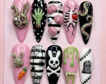 May include: A set of ten long, pointed acrylic nails with a Halloween theme. Designs include a zombie bunny, a green hand, brains, a rib cage, tentacles, spiderwebs, a skull and crossbones, dripping slime, and a tombstone.