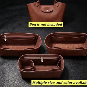 Pode incluir: Três organizadores de bolsa de feltro marrom com múltiplos compartimentos internos, incluindo bolsos com zíper e aberturas. Os organizadores possuem um design estruturado para manter a forma. O texto diz Bag is not included.