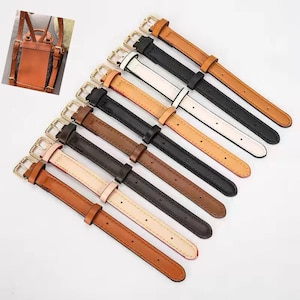 May include: A collection of eight watch straps in various colors including tan, black, white, and dark brown, each featuring a gold-tone metal buckle and a sliding keeper. A small inset image shows a brown backpack with matching straps attached.
