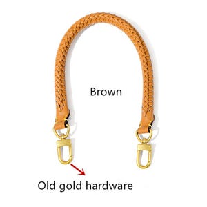 May include: A brown, braided handbag handle with old gold hardware. The handle is arched, with a woven design and leather accents. The hardware includes two clasps for easy attachment. The word "Brown" is printed on the image.