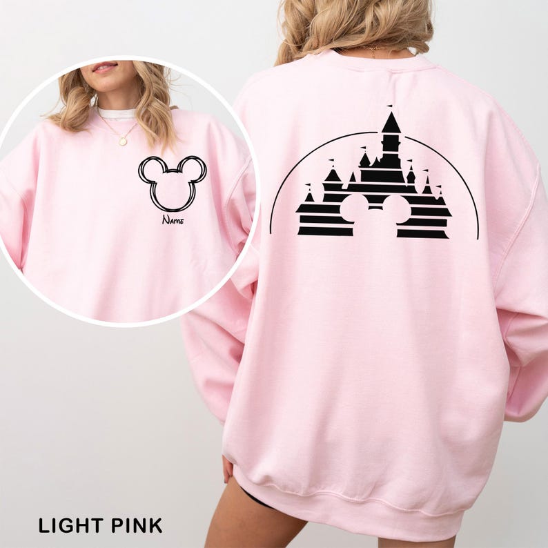 Pu&ograve; includere: Felpa rosa chiaro con un contorno nero della testa di Topolino sul davanti e un disegno di castello sul retro. Il design anteriore include la parola "Name" sotto la testa di Topolino. Il testo "LIGHT PINK" &egrave; in basso.
