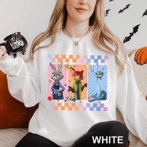 May include: White sweatshirt with a design of three cartoon characters: a bunny in a police uniform, a fox in a green shirt, and a snake. The design includes star accents and a checkered pattern. The word "WHITE" is printed at the bottom.