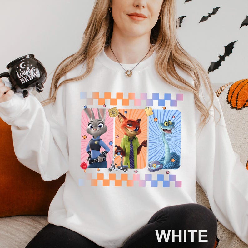 May include: White sweatshirt with a design of three cartoon characters: a bunny in a police uniform, a fox in a green shirt, and a snake. The design includes star accents and a checkered pattern. The word "WHITE" is printed at the bottom.