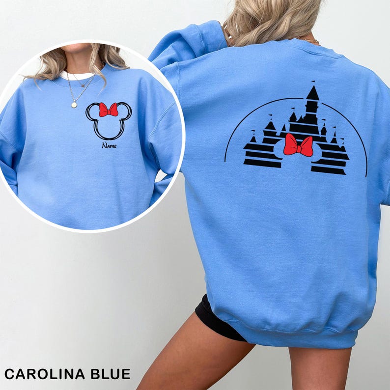 Pu&ograve; includere: Felpa blu Carolina con un design di Minnie Mouse, fiocco rosso e la parola "Name". Il retro presenta un castello nero e un fiocco rosso. La felpa &egrave; di colore azzurro.