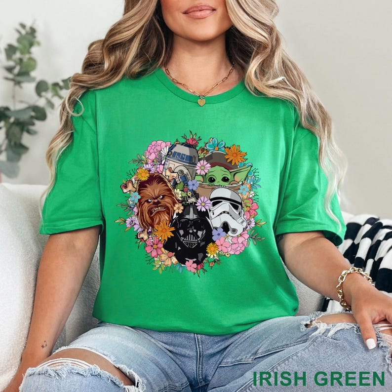 May include: Irish green t-shirt featuring a floral design with Star Wars characters including Chewbacca, Darth Vader, a Stormtrooper, R2-D2, and Grogu. The text "IRISH GREEN" is printed at the bottom of the image.