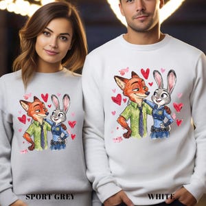 May include: Sport grey and white sweatshirts featuring a watercolor illustration of Nick Wilde and Judy Hopps from Zootopia, surrounded by red hearts. The sweatshirts have the words "SPORT GREY" and "WHITE" printed at the bottom.