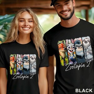 May include: Black t-shirts with a colourful graphic of characters from "Zootopia 2". The design includes Nick Wilde, Judy Hopps, and other characters. The text "Zootopia 2" is written in a cursive font below the characters. The word "BLACK" is at the bottom.