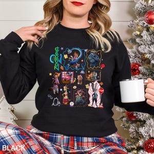 May include: Black crewneck sweatshirt featuring a colorful graphic of characters from the animated film Zootopia. The design includes the film's title and various character illustrations. The word "BLACK" is printed at the bottom.
