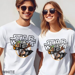 May include: A white ceramic mug with a black handle and the text "But First, Coffee" in a bold, black font. The mug is filled with a dark liquid, likely coffee, and sits on a light-colored surface.