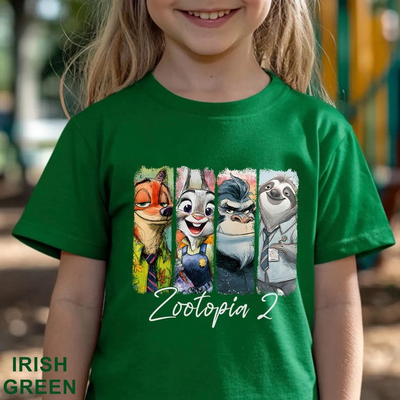May include: A green t-shirt with a graphic of characters from the film Zootopia. The graphic shows Nick Wilde, Judy Hopps, a gorilla, and Flash the sloth. The text "Zootopia 2" is written in white script below the characters. The shirt is Irish green.