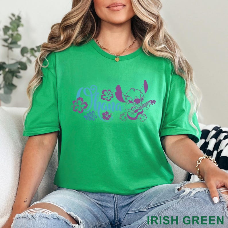 May include: A green t-shirt with a graphic of a cartoon character playing a guitar, with the word "Aloha" and floral accents in blue and purple. The text "Irish Green" is at the bottom of the shirt.