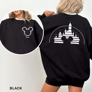 Pu&ograve; includere: Felpa nera con un contorno bianco di Mickey Mouse sul davanti e sul retro. Il davanti presenta il contorno e la parola "Name". Il retro ha un disegno di castello con una silhouette di Mickey Mouse. La felpa ha un colletto bianco.