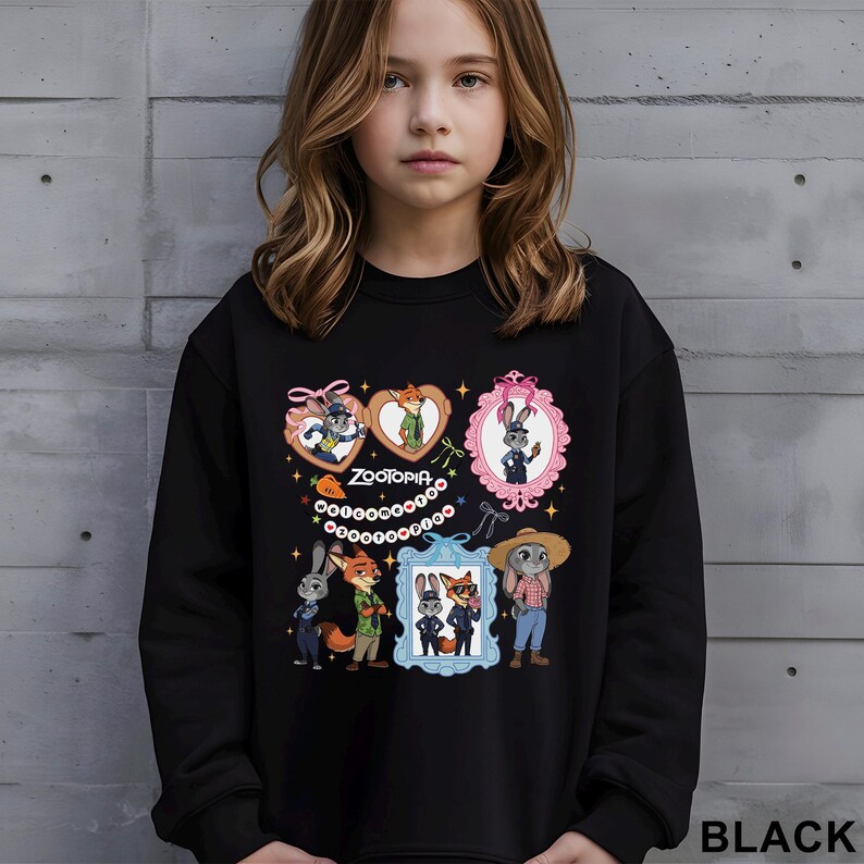 Op de afbeelding: Zwarte sweatshirt met illustraties van Zootopia-personages in hartvormige en ovale frames. Het woord "ZOOTOPIA" is in het wit gedrukt. De sweatshirt heeft een ronde hals en lange mouwen. Het woord "BLACK" staat rechtsonder.