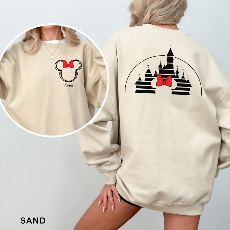 Pu&ograve; includere: Felpa color sabbia con design di Minnie Mouse. La parte anteriore mostra un contorno di Minnie Mouse con un fiocco rosso e la parola "Name". Il retro presenta una silhouette di castello con un fiocco rosso, tutto in nero. Un top comodo e casual.