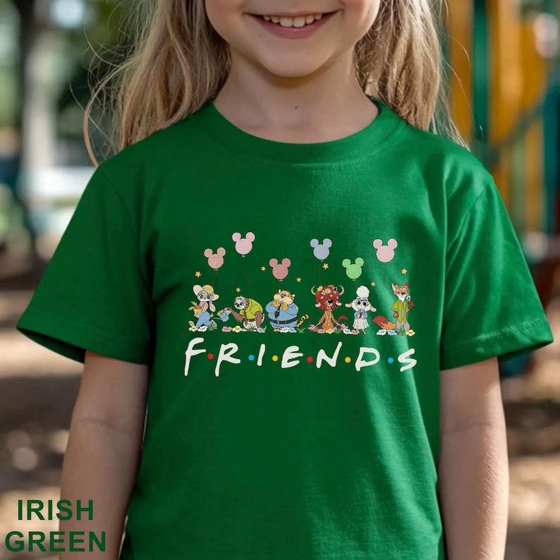 May include: Green t-shirt with a cartoon graphic and the word "FRIENDS" in white. The design includes Mickey Mouse head shapes in pink, blue, and green. The shirt is made of a soft material. The text "IRISH GREEN" is at the bottom.
