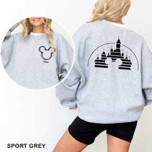 Pu&ograve; includere: Felpa grigio sport con un design a testa di Topolino nero sul davanti e sul retro. Il design anteriore include un nome sotto la testa di Topolino. Il design posteriore presenta una silhouette di castello all'interno di una forma a testa di Topolino.