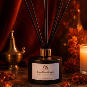 May include: A matte black reed diffuser bottle with a gold-toned collar and six black reeds. The white label features the text 6S Sixth Scents Lumière Rouge, Warm Amber | Saffron | Cedarwood, and Luxury Reed Diffuser 200ml in black lettering.