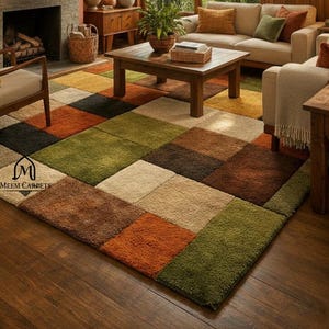 Op de afbeelding: Een woonkamer met een veelkleurig vierkant patroon tapijt. Het tapijt heeft vierkanten van oranje, groen, bruin, zwart en beige. De kamer heeft lambrisering, een open haard en een bank. Het logo "MEEM CARPETS" is zichtbaar.