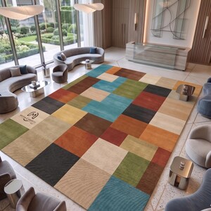 Pode incluir: Um tapete retangular grande com uma grade de quadrados multicoloridos em tons de azul, verde, marrom, laranja e bege. O tapete tem uma superfície texturizada e inclui um pequeno logotipo com o texto Meem Carpets impresso em um canto.