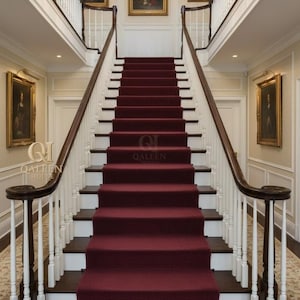 May include: A grand staircase with burgundy carpet and dark wood steps. White balusters and a dark wood handrail lead up to a second-floor landing. The walls are adorned with framed portraits and a crystal chandelier hangs overhead. The logo "QALEEN HOUSE" is visible.