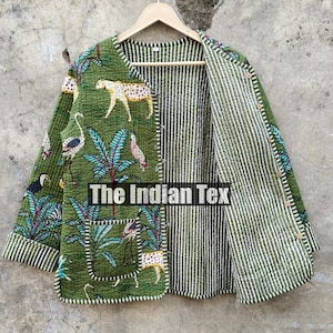May include: Green quilted jacket with a jungle-themed print featuring leopards, birds, and foliage. The jacket has a striped interior and cuffs, and two front pockets. The text "The Indian Tex" is visible on the jacket.