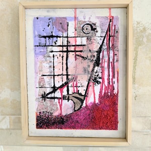 Könnte beinhalten: Abstrakte Mixed-Media-Kunst in einem hellen Holzrahmen. Die Kunst zeigt eine Collage aus Texturen, darunter Papier und Farbe, mit einer Farbpalette aus Rosa, Rot, Schwarz und Lila. Die Komposition umfasst Tropfen, Linien und strukturierte Bereiche.