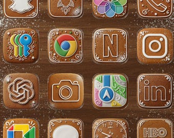 May include: A collection of sixteen gingerbread cookies, each decorated to resemble app icons. The cookies are arranged on a wooden surface and include designs for Snapchat, Instagram, and HBO Max. White icing details the edges and designs.