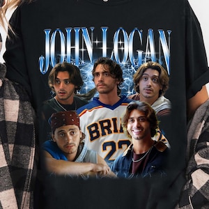 May include: A black short-sleeve t-shirt featuring a graphic print of John Logan with multiple photographic portraits of the same individual. The text JOHN LOGAN appears in a stylized blue font at the top above the collage of images.