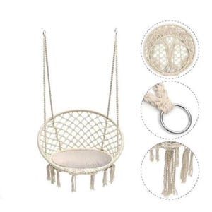 Könnte beinhalten: Ein cremefarbener Makramee-Schaukelstuhl mit rundem Sitz und Rückenlehne. Der Stuhl hat ein gewebtes Netzdesign und ein weiches, helles Kissen. Die Schaukel hängt an zwei stabilen Seilen und hat dekorative Fransen. Für den Innen- oder Außenbereich geeignet.