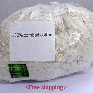 May include: A white ceramic mug with a black handle and the text "But First, Coffee" in a bold, black font. The mug is set against a blurred background, suggesting a cozy setting.